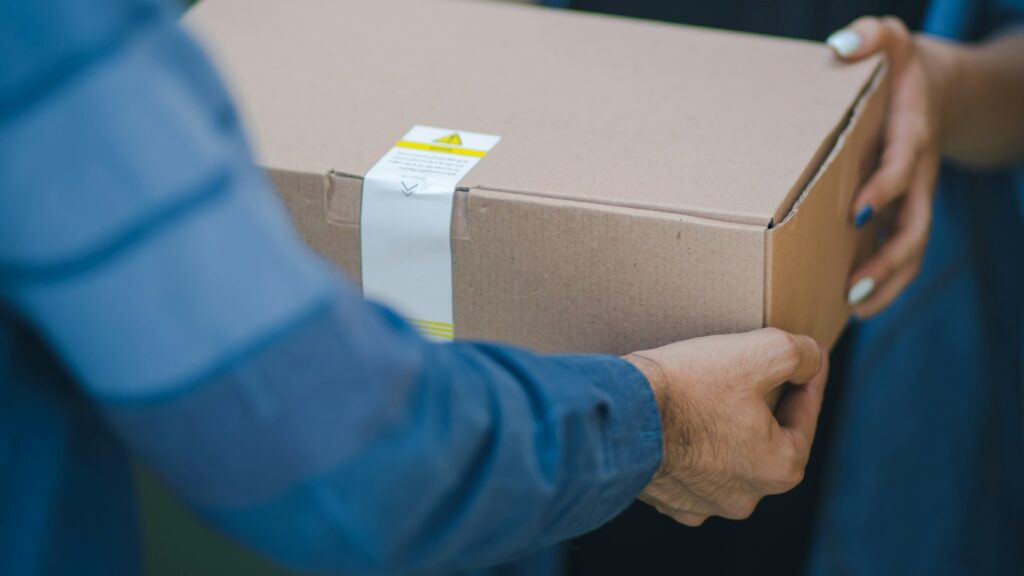 Hands holding a sealed shipping box ready for FBA