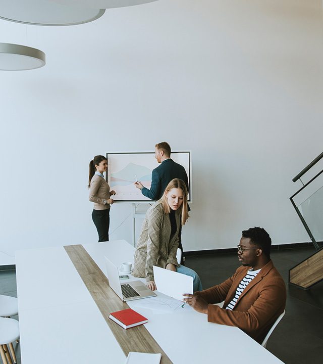 Team of professionals analyzing data and planning Amazon brand distribution strategy in a modern office